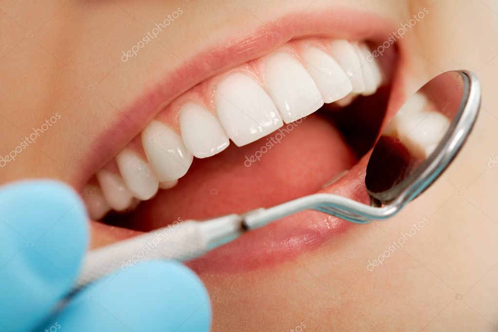 Dentista che cura una carie con strumenti odontoiatrici