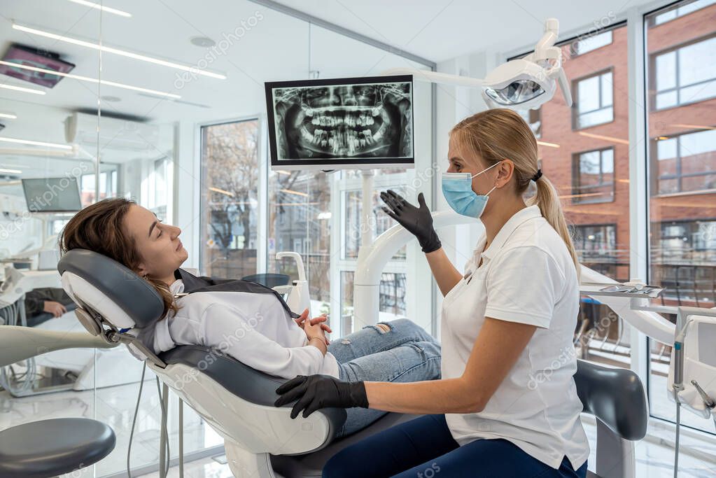 Dentista che spiega un piano di cura a un paziente in modo rassicurante